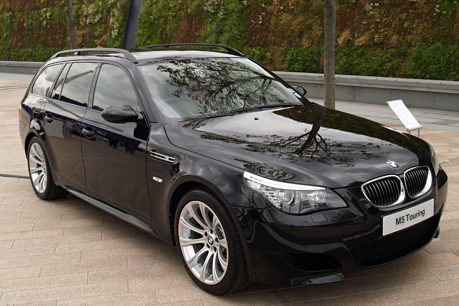 Black facelifted wagon with sleek headlights and alloy wheels