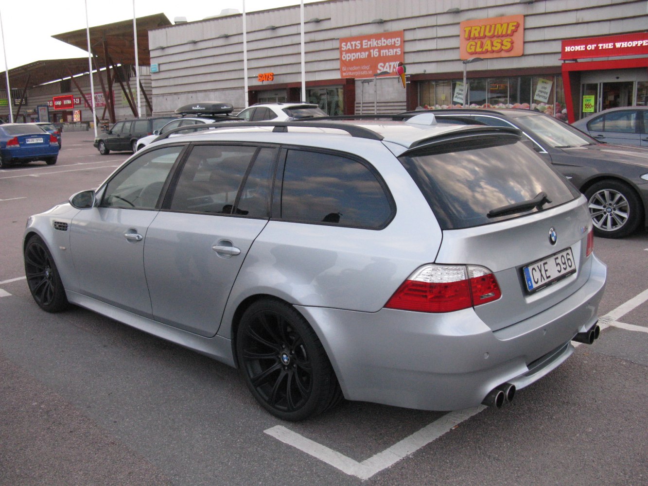 Silver wagon with black wheels, rear spoiler, quad exhaust