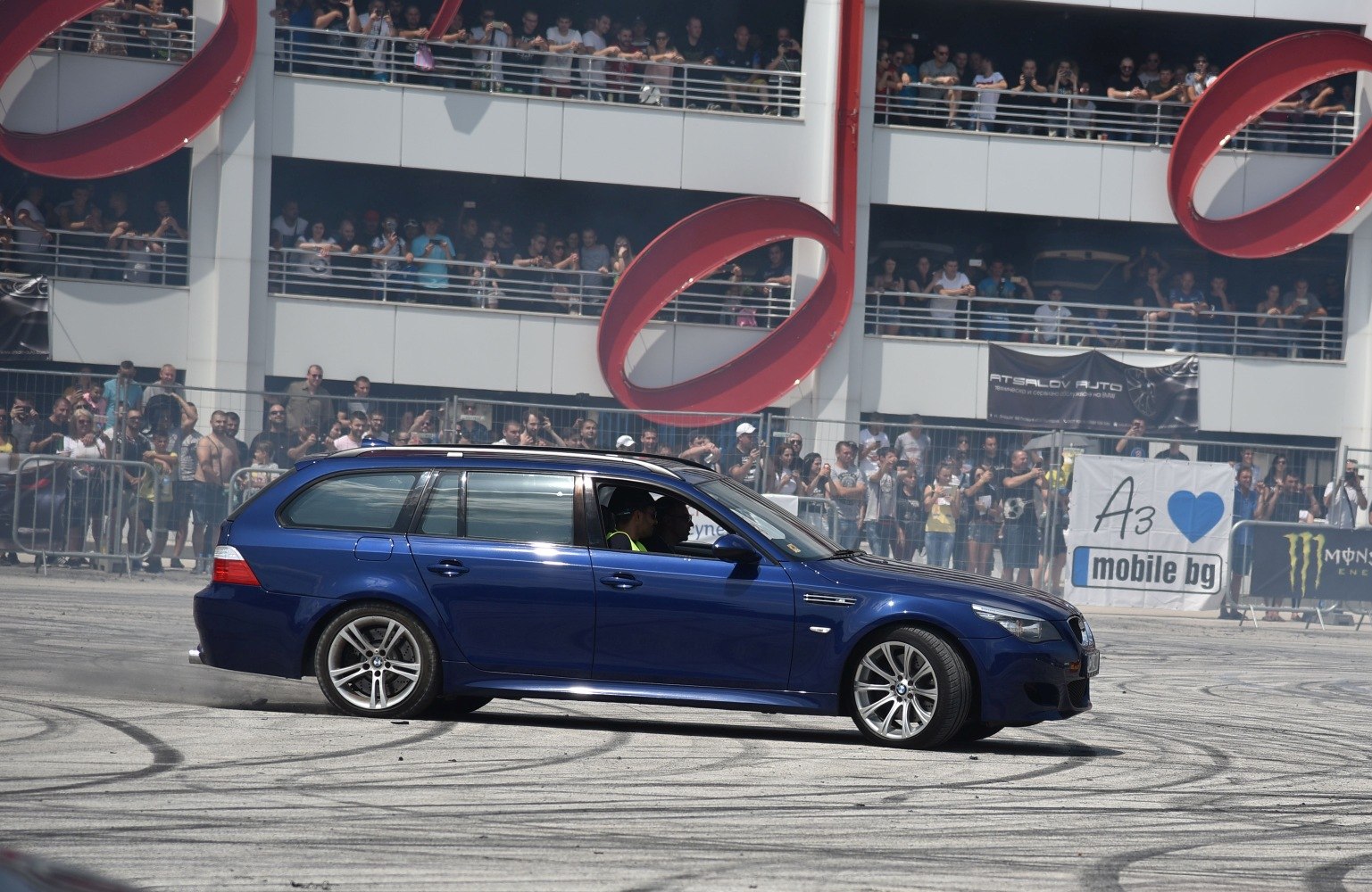 Blue performance wagon drifting with rear tire smoke on race track