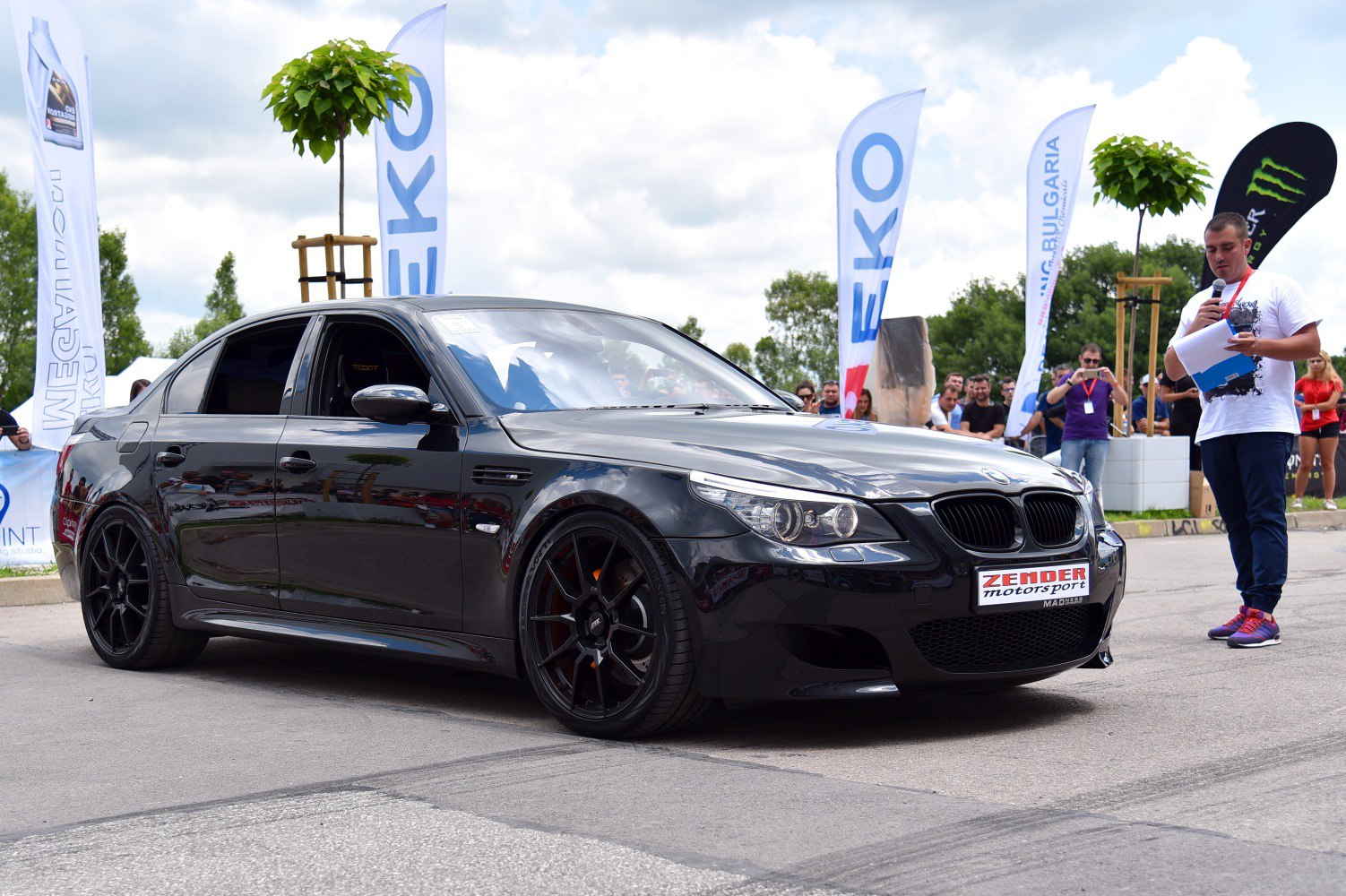 Black sporty sedan with custom black wheels and aggressive front design