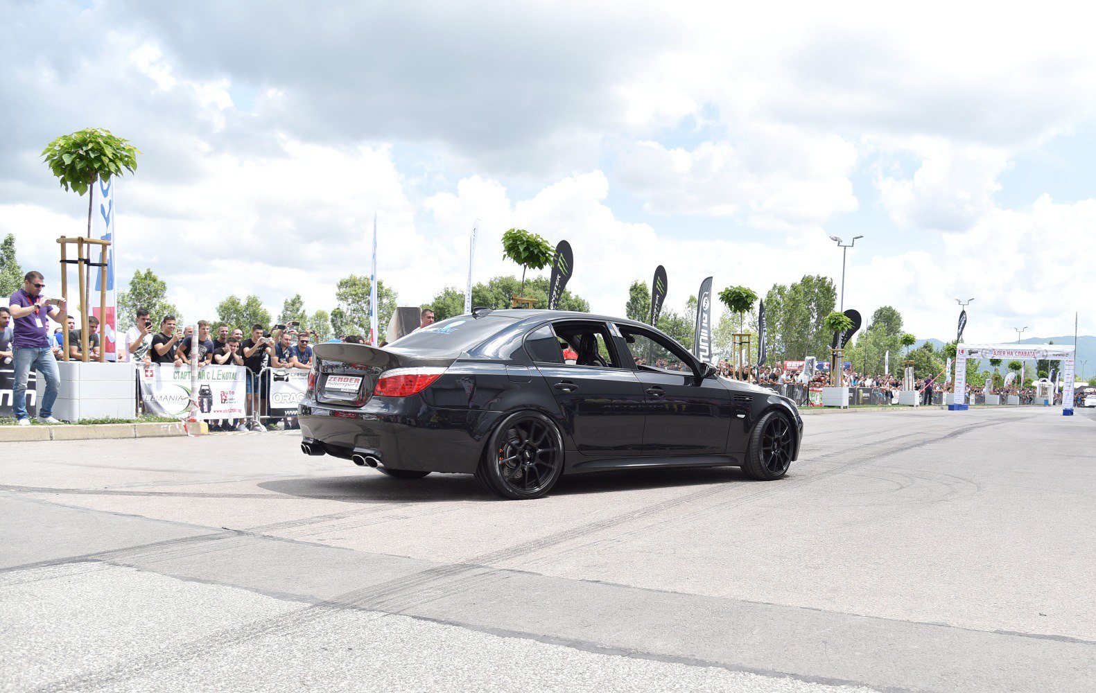 Black sedan with custom black rims and quad exhaust