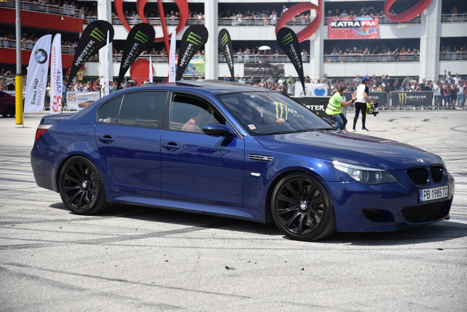 Blue sedan with black alloy wheels at motorsport event