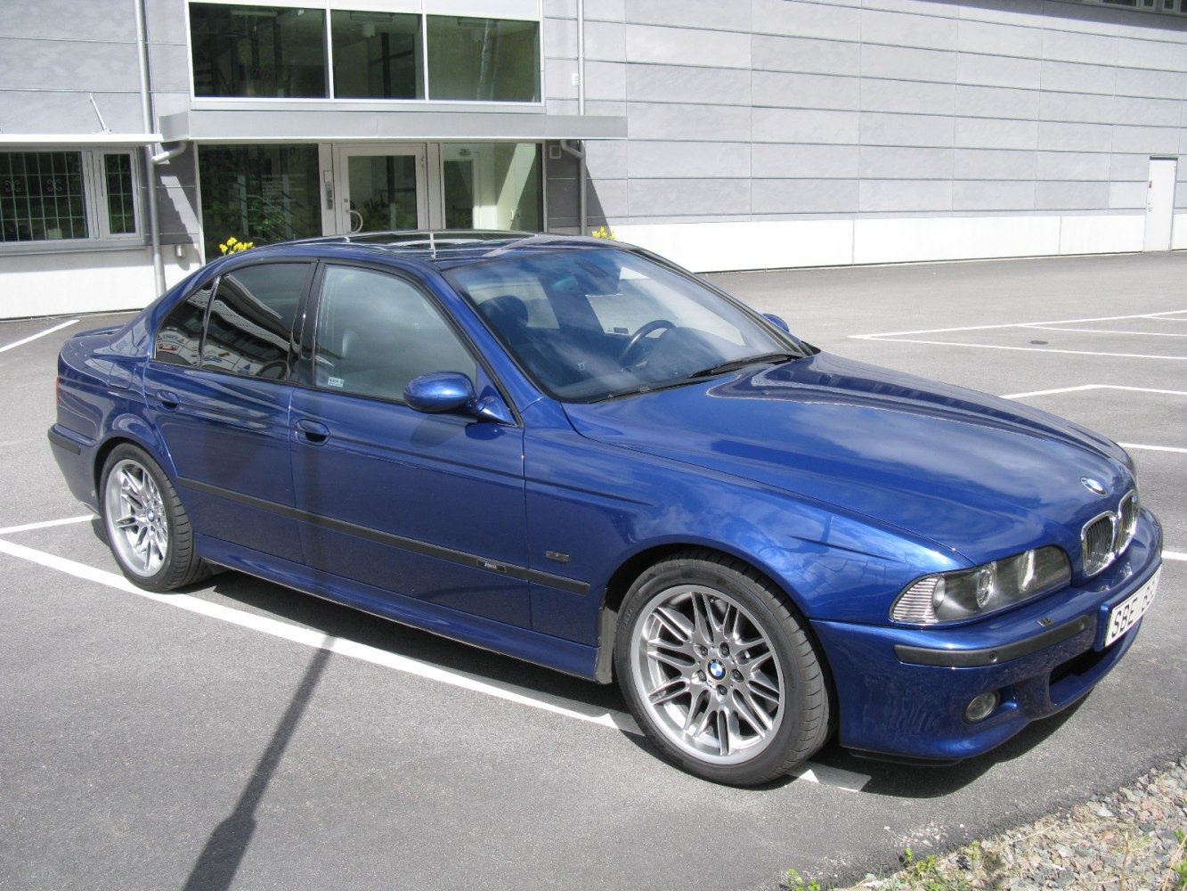 Blue sedan with multi-spoke alloy wheels and sporty front design