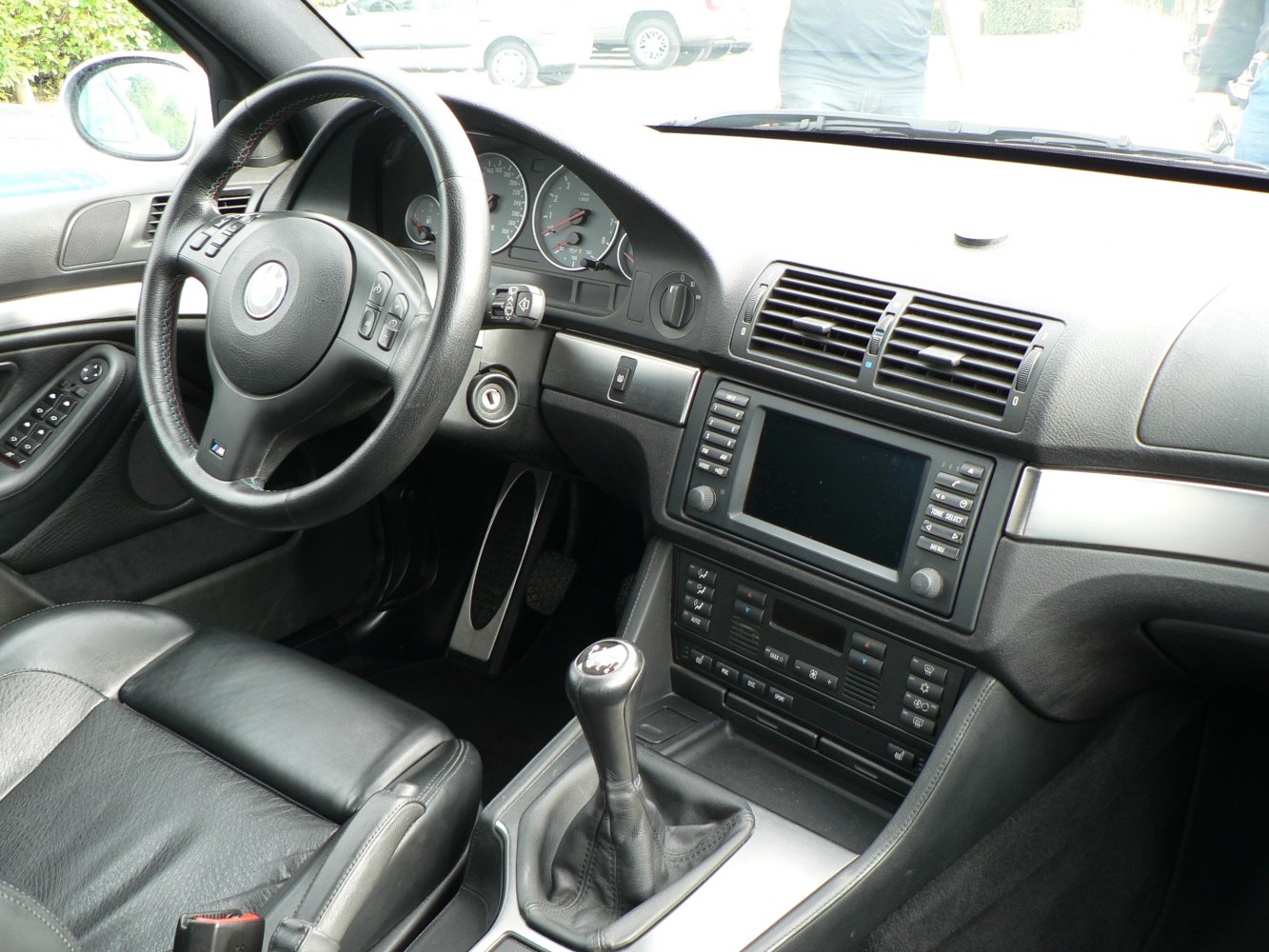 Interior steering wheel and manual gear shift of a luxury sports sedan.