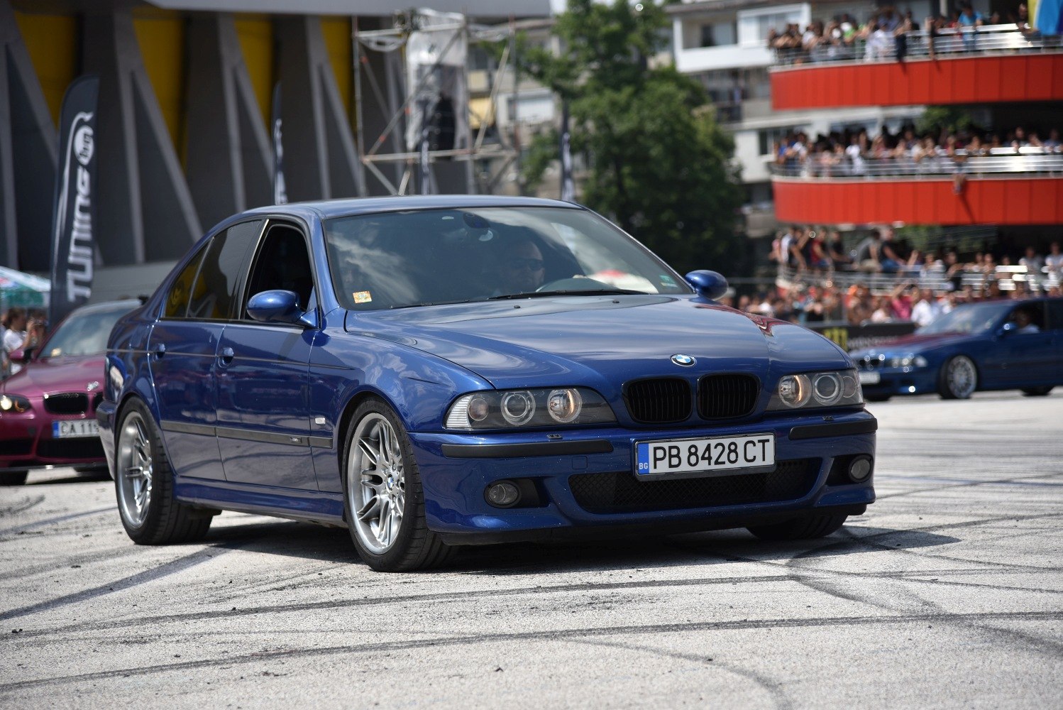 Front view of a sporty sedan with dual circular headlights and alloy wheels