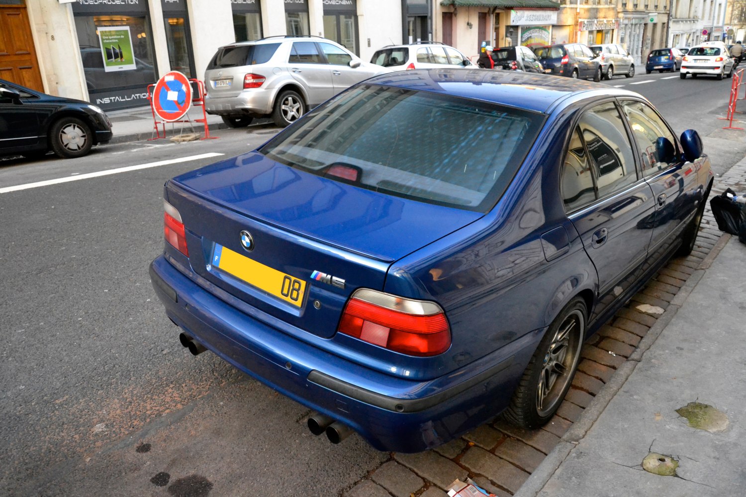 Blue sedan rear with dual exhaust and red tail lights