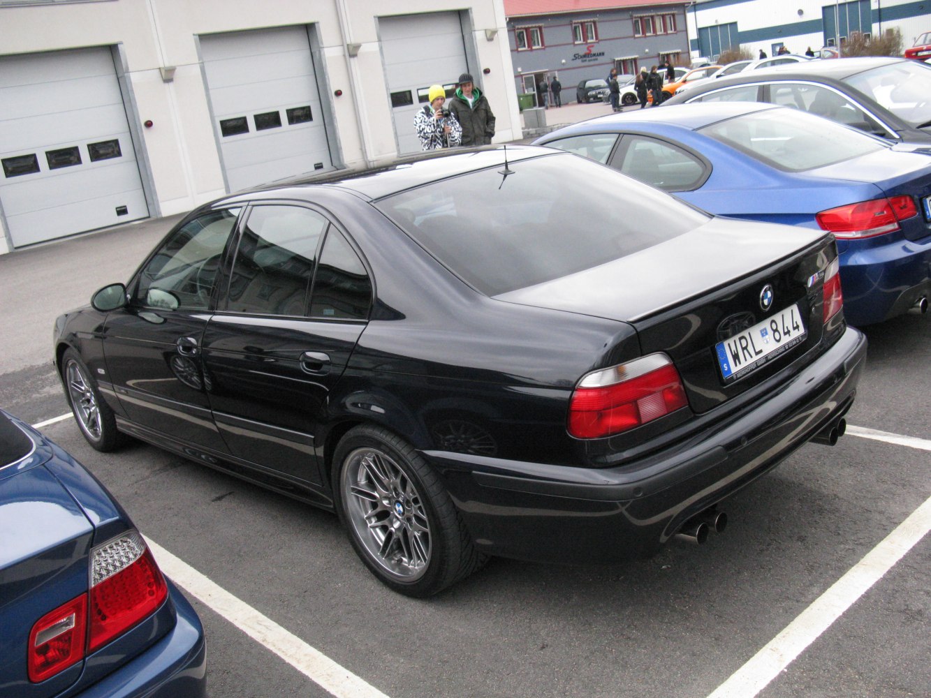 Rear angle of luxury sedan with quad exhaust and multi-spoke wheels