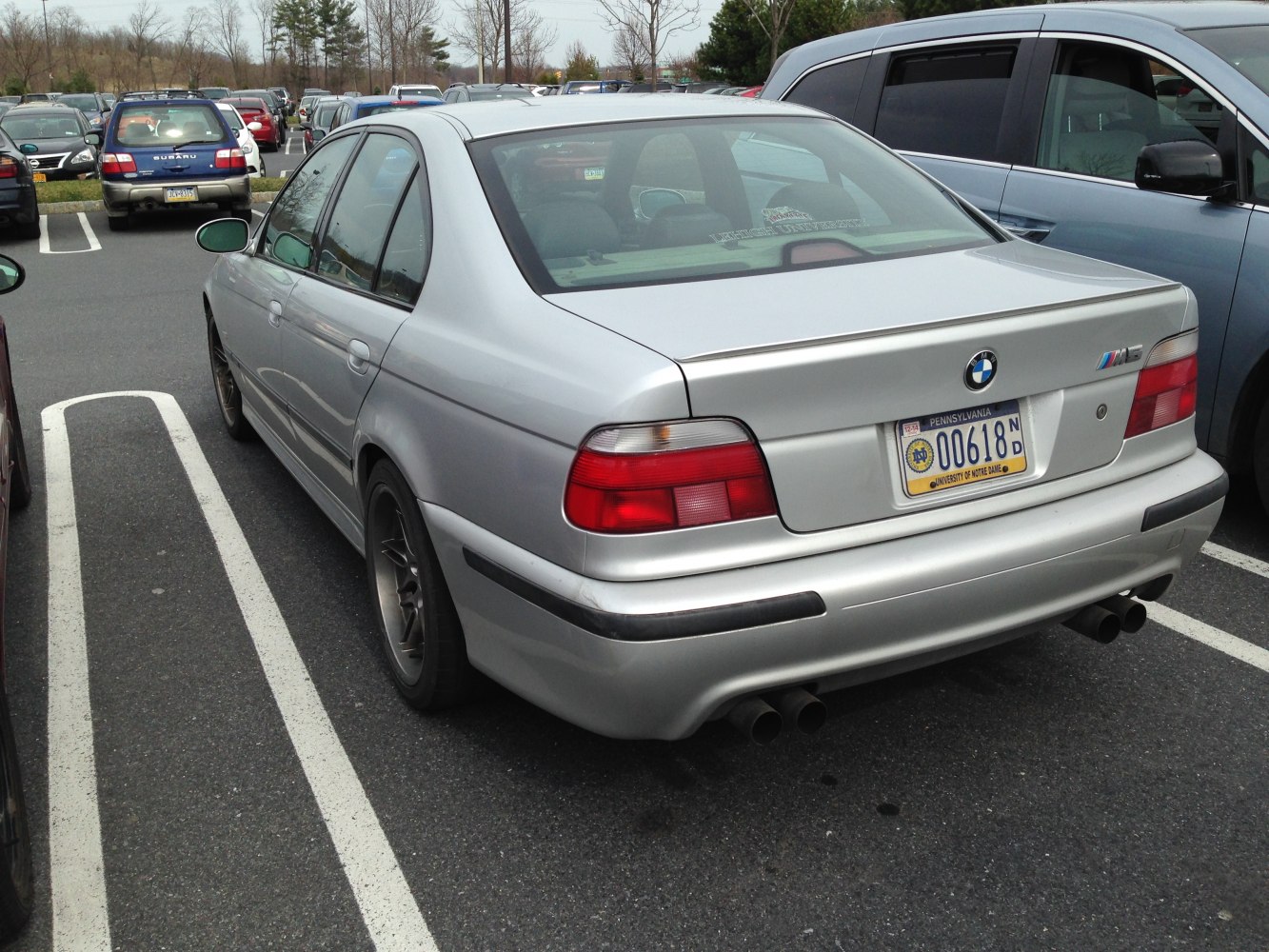 Rear view with dual exhaust, taillights, and trunk spoiler