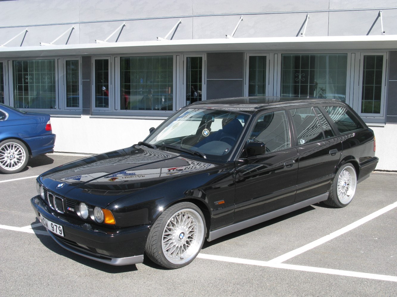 Black E34 style station wagon with quad headlights and alloy wheels