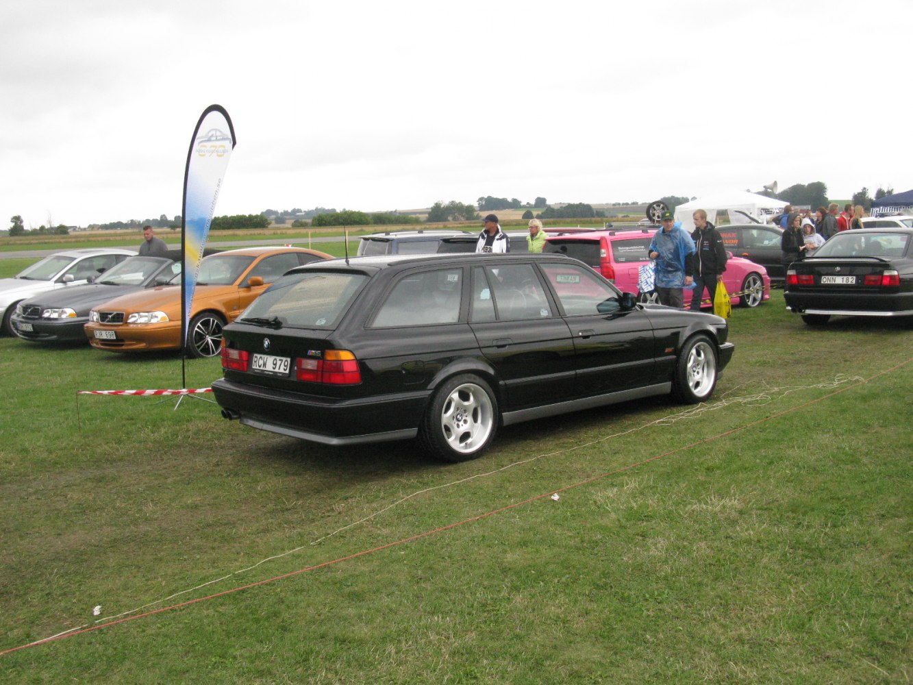 Black classic wagon with 5-spoke alloy wheels and roof spoiler.