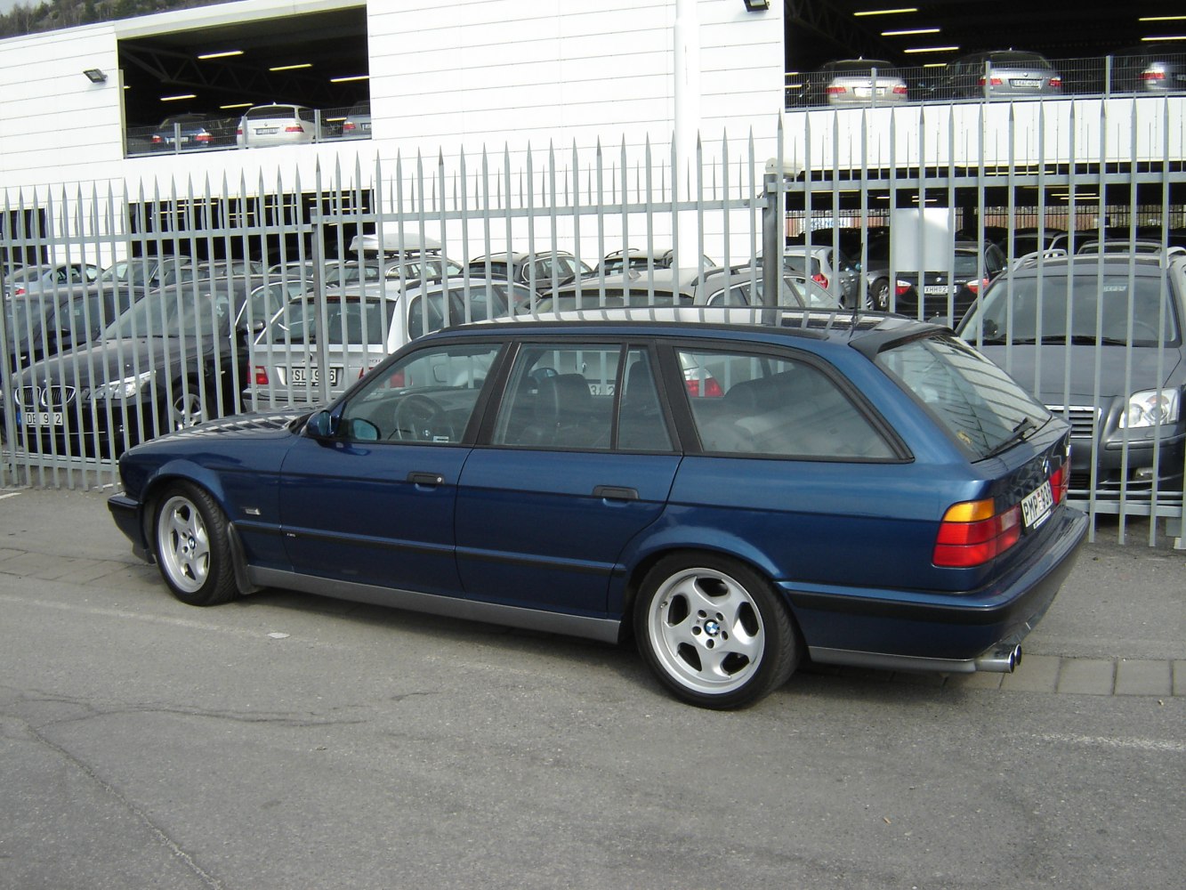 Blue station wagon with five-spoke wheels and rear side profile