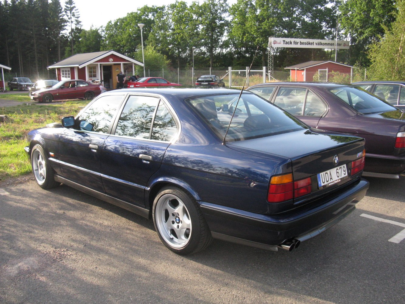 Classic sedan with alloy wheels and rear spoiler in a parking setting