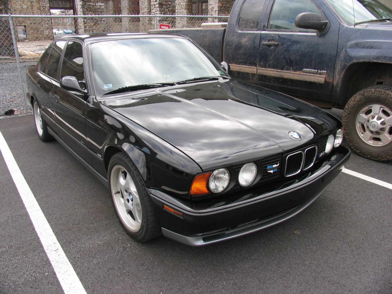 Front and side view of a classic sedan with round dual headlights and five-spoke wheels