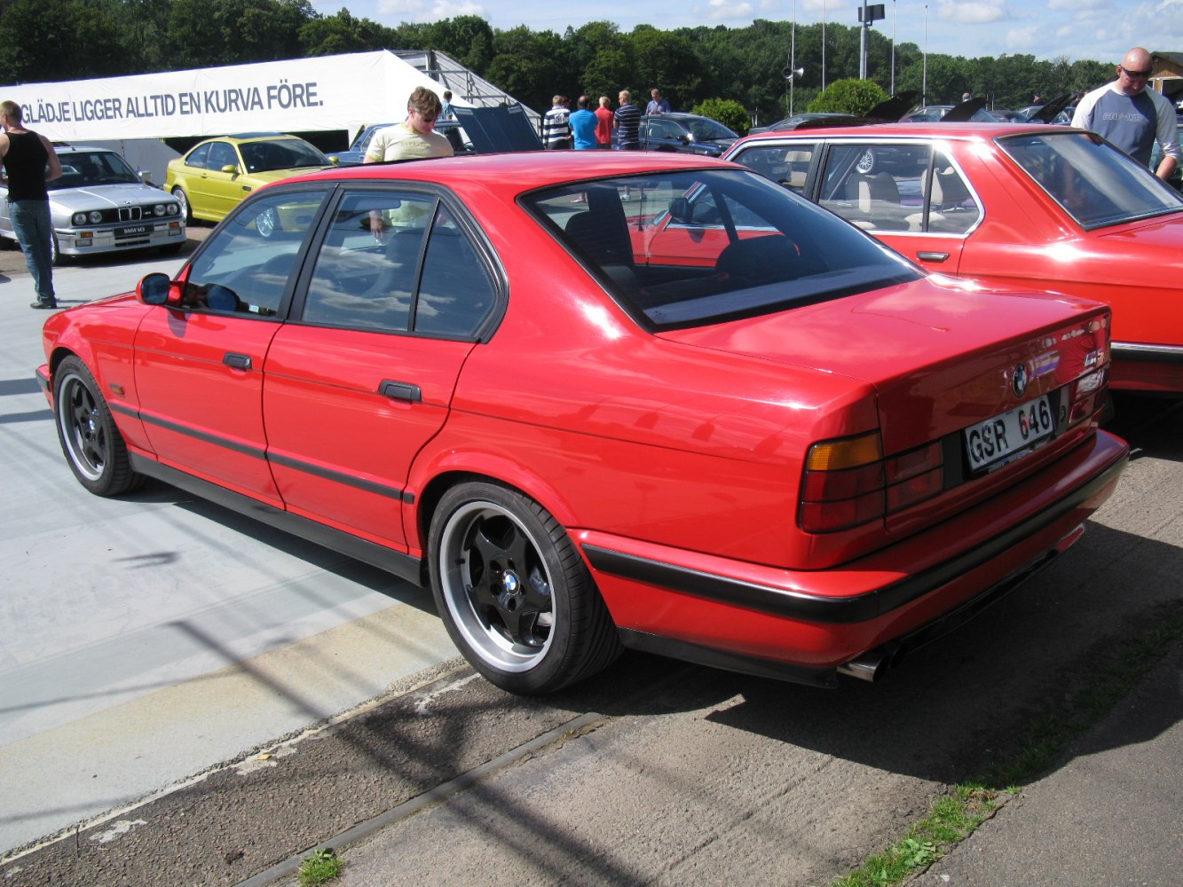 Red four-door sedan with black rims and sporty rear details