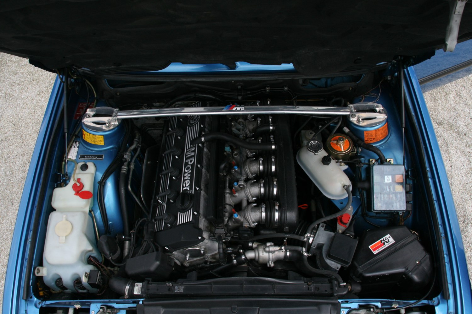 Inline-6 engine with strut brace in an engine bay