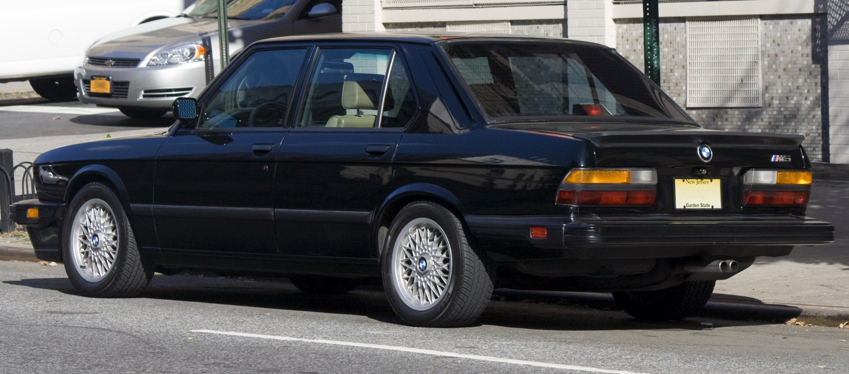 Black sedan with mesh alloy wheels and rear spoiler