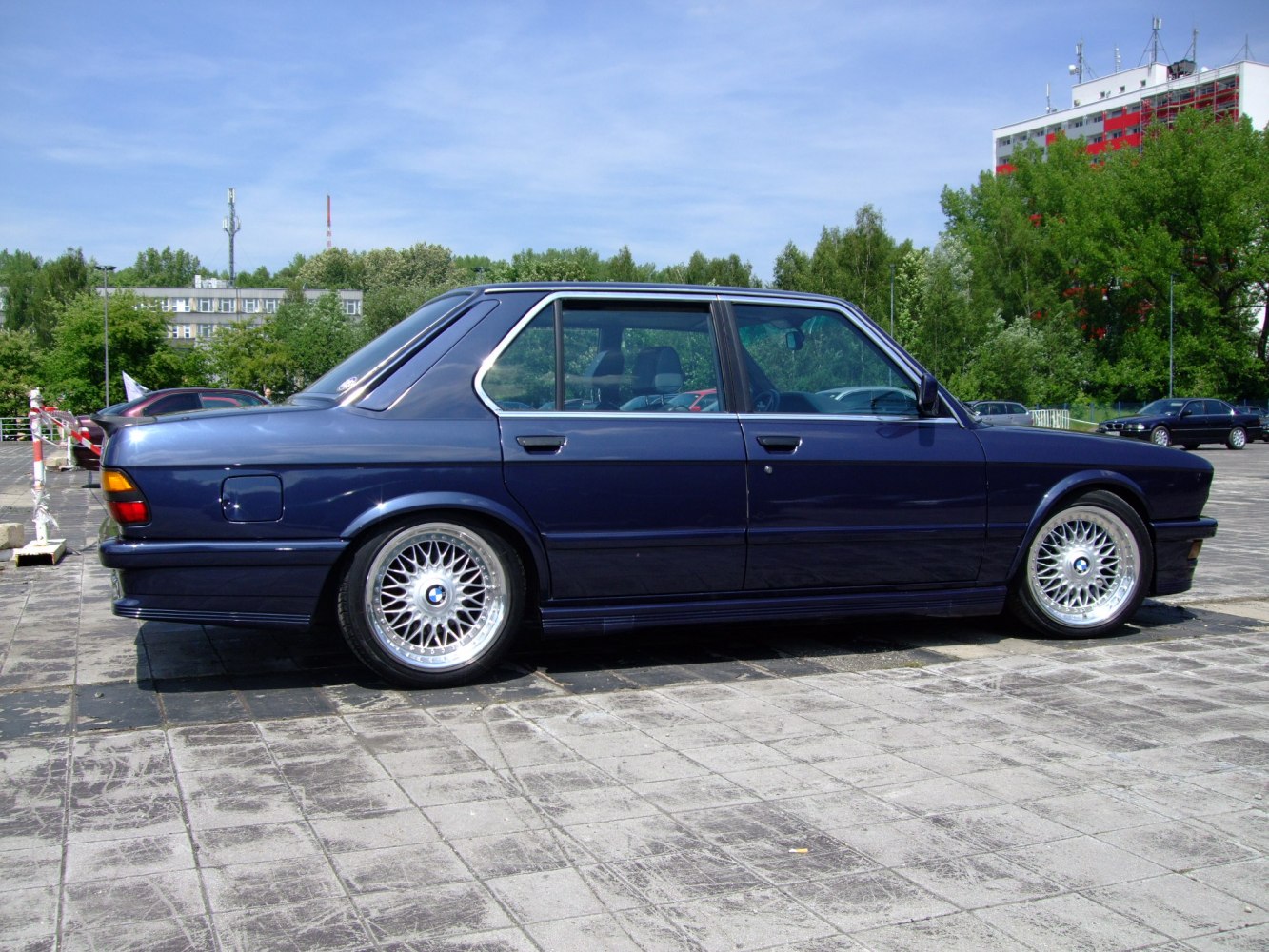 Vintage sedan with multi-spoke alloy wheels and rear spoiler side view
