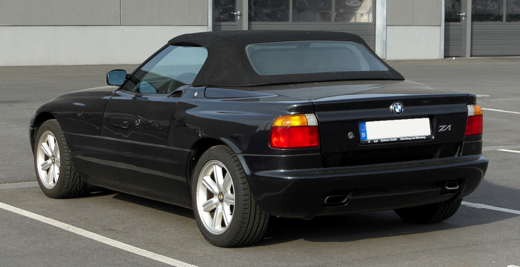 Convertible with soft top, rear dual exhaust, and alloy wheels.