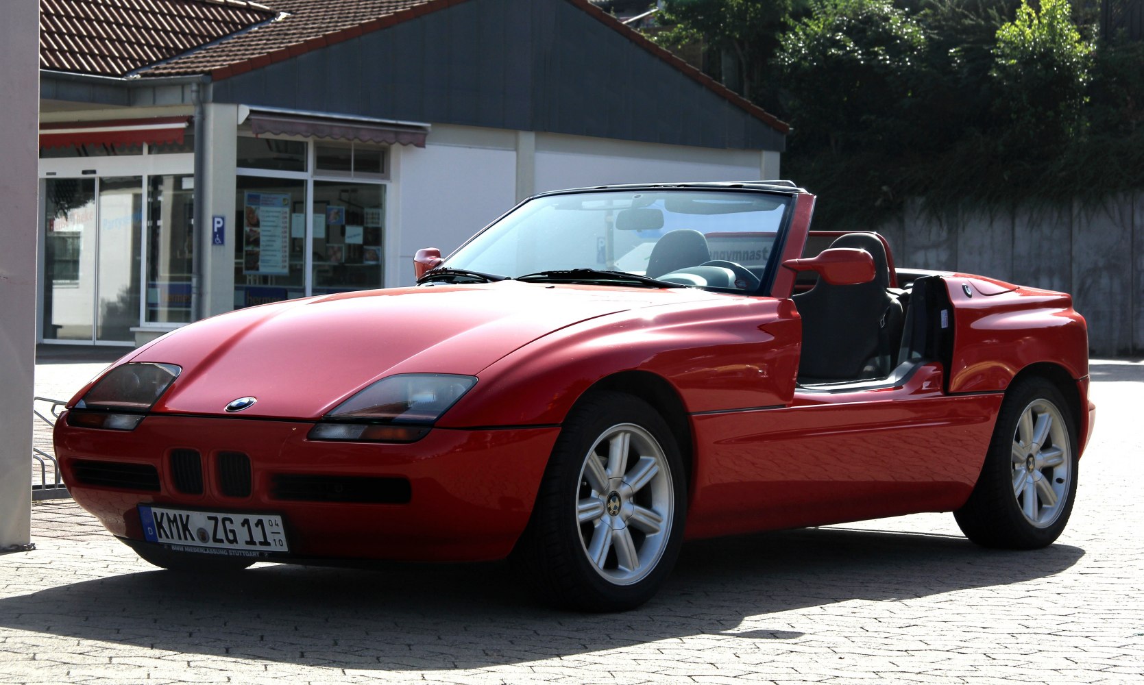 Red convertible with retractable doors and low-profile sleek design