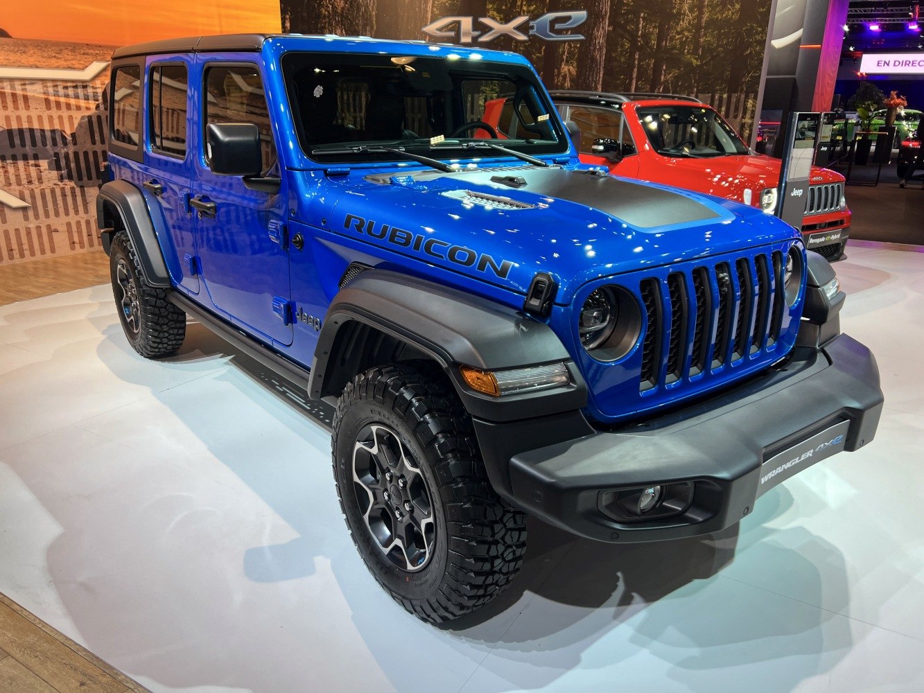 Blue off-road SUV with aggressive tires and seven-slot grille