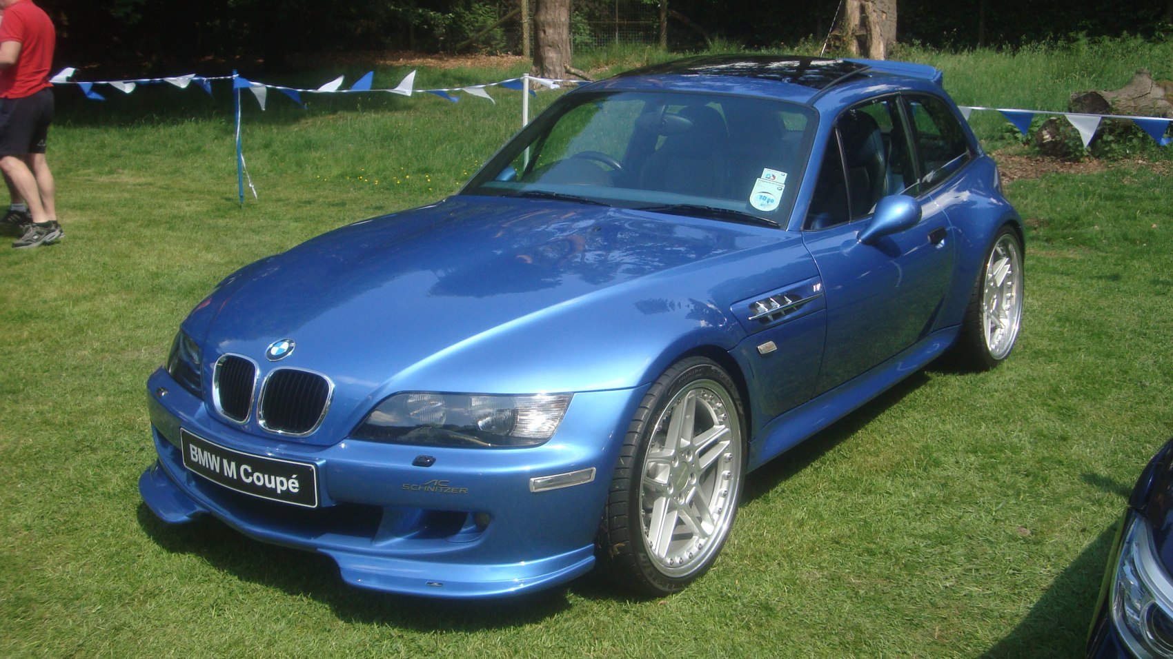 Blue sports coupe with aggressive front bumper and alloy wheels