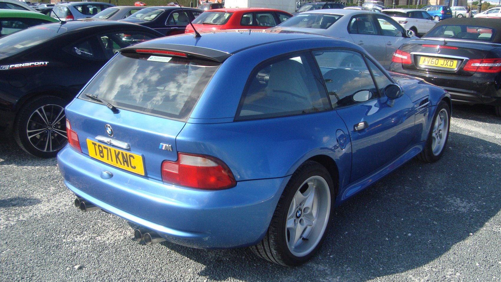 Blue compact hatchback with dual exhausts and sporty curves