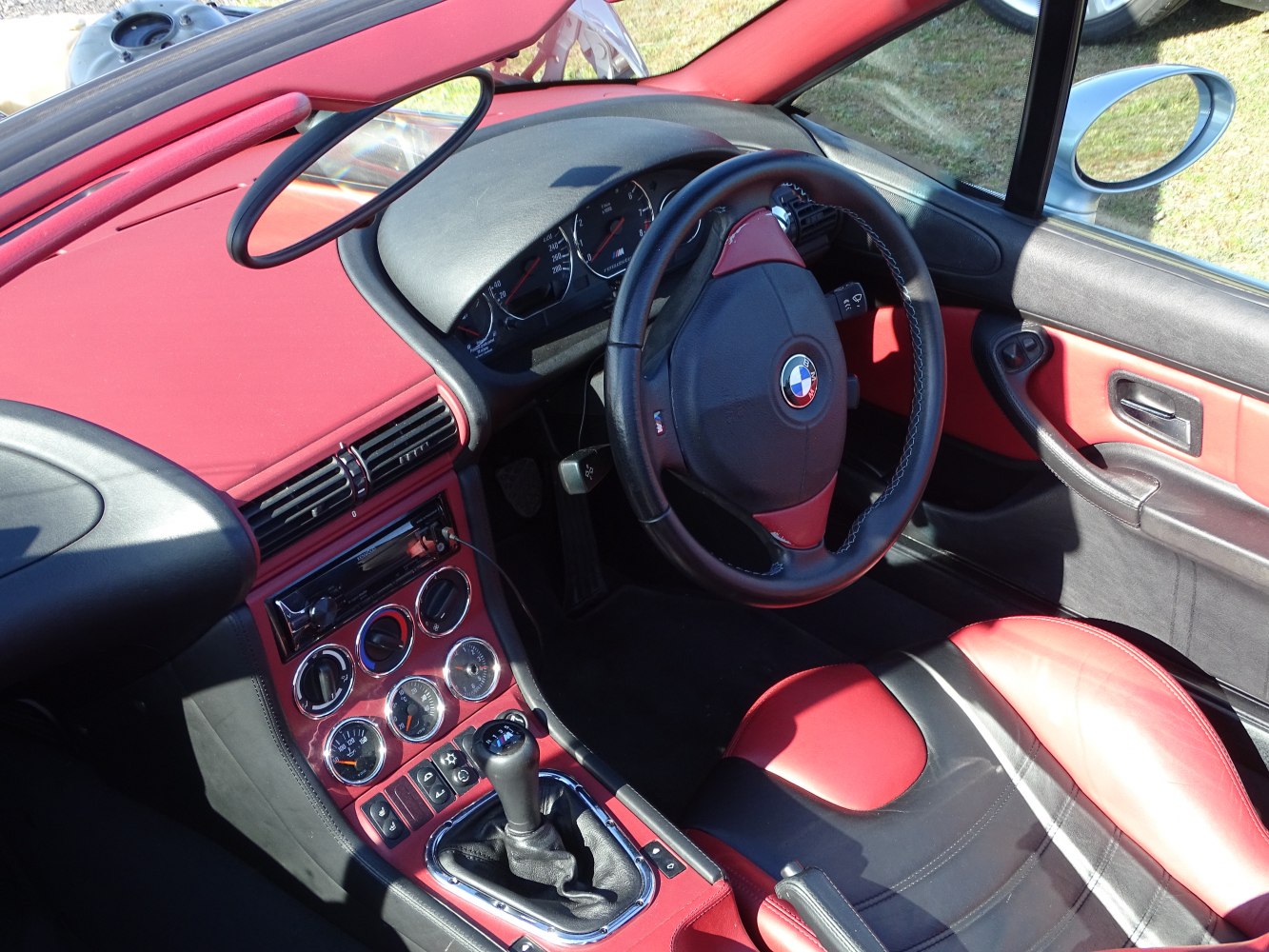 Sporty red and black interior with manual gear shift and detailed dashboard