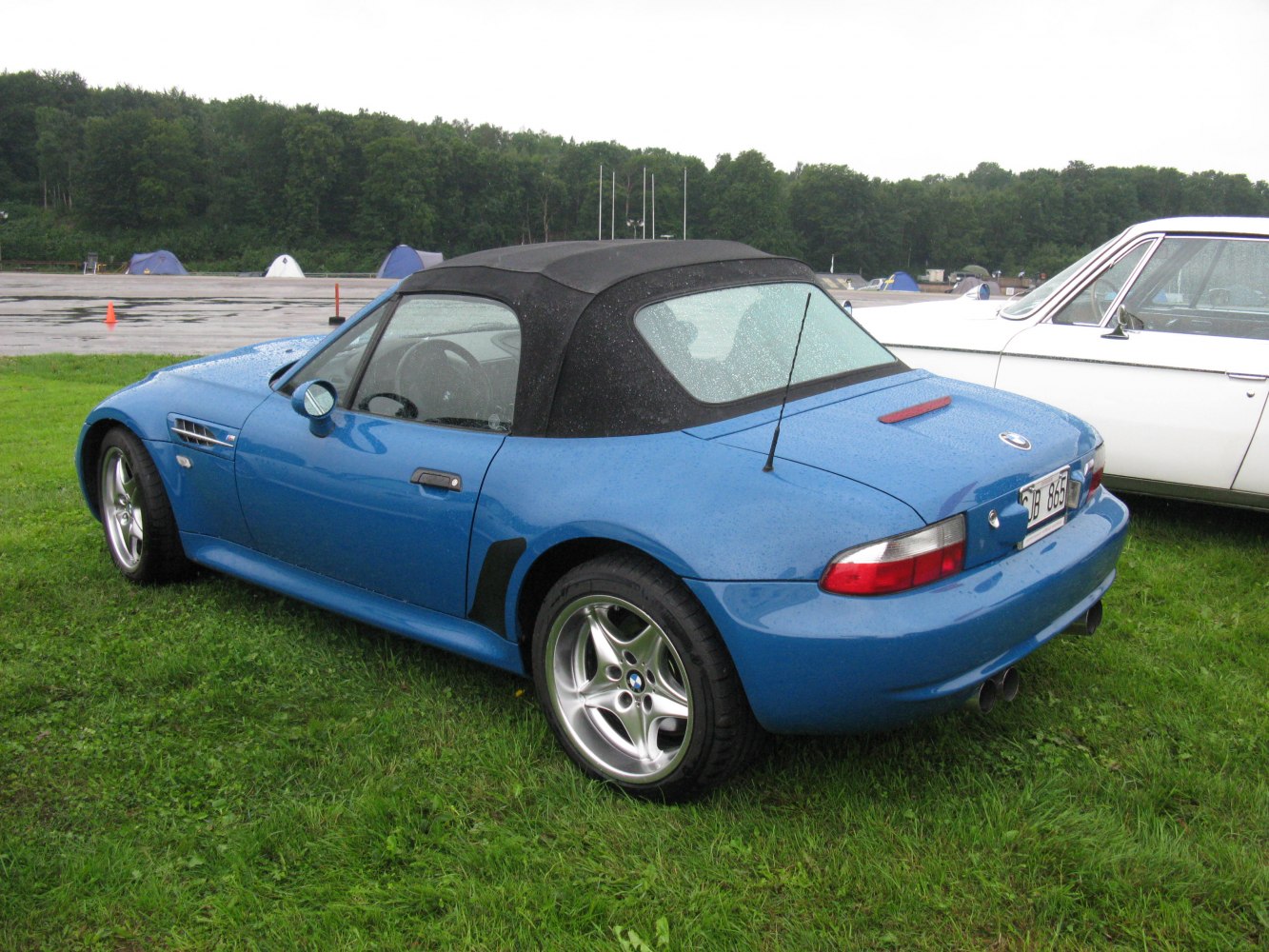 Convertible roadster with soft top, sporty alloy wheels, and dual exhausts