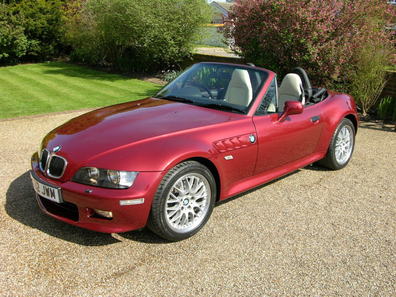 Red convertible roadster with alloy wheels and classic sporty design.