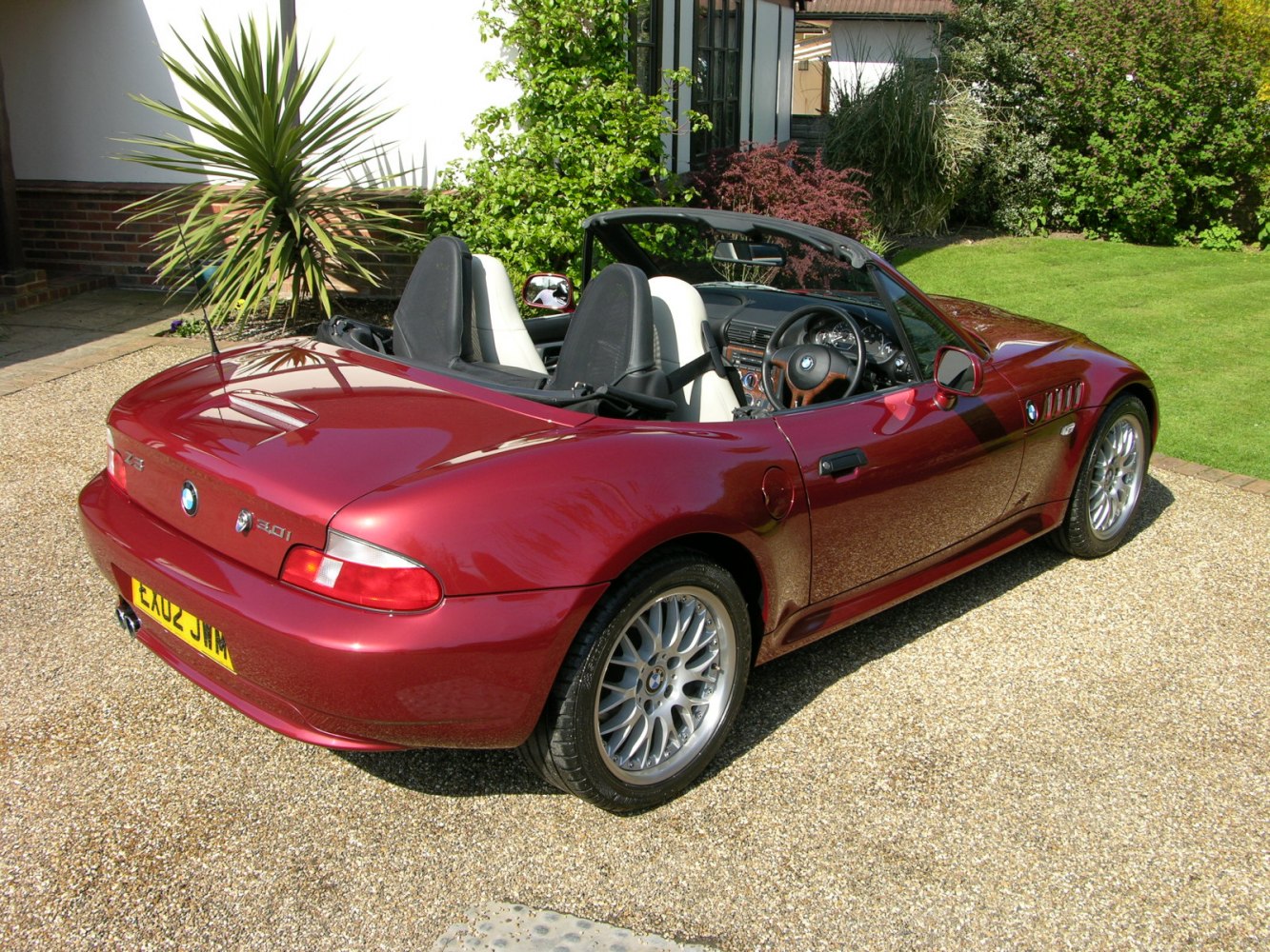 Rear side view of a red convertible with alloy wheels and sporty design