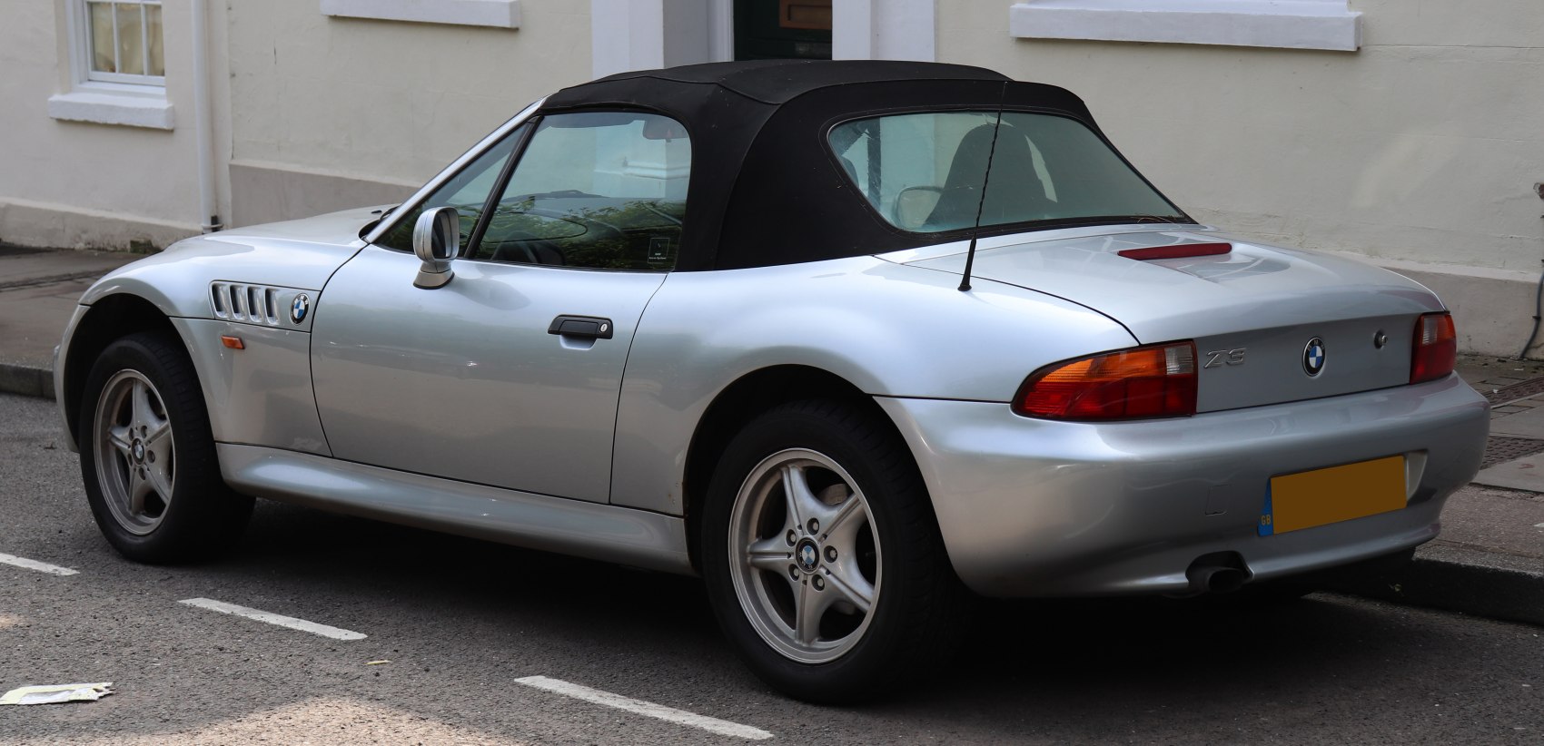 Silver convertible soft top with classic 5-spoke alloy wheels and rear antenna