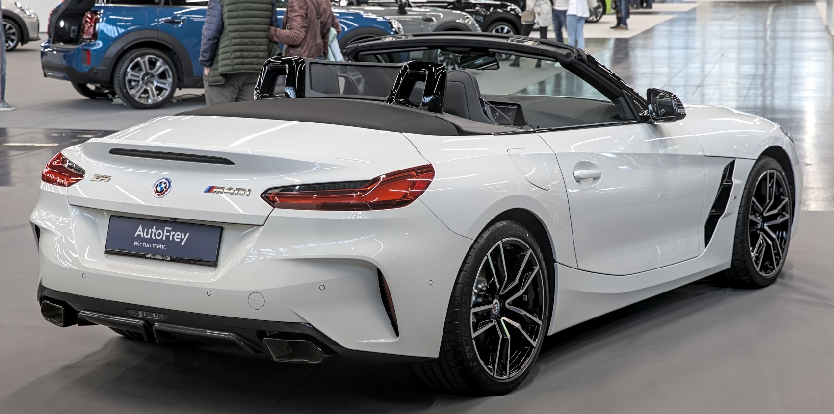 Rear view of white convertible with black alloy wheels and dual exhaust.