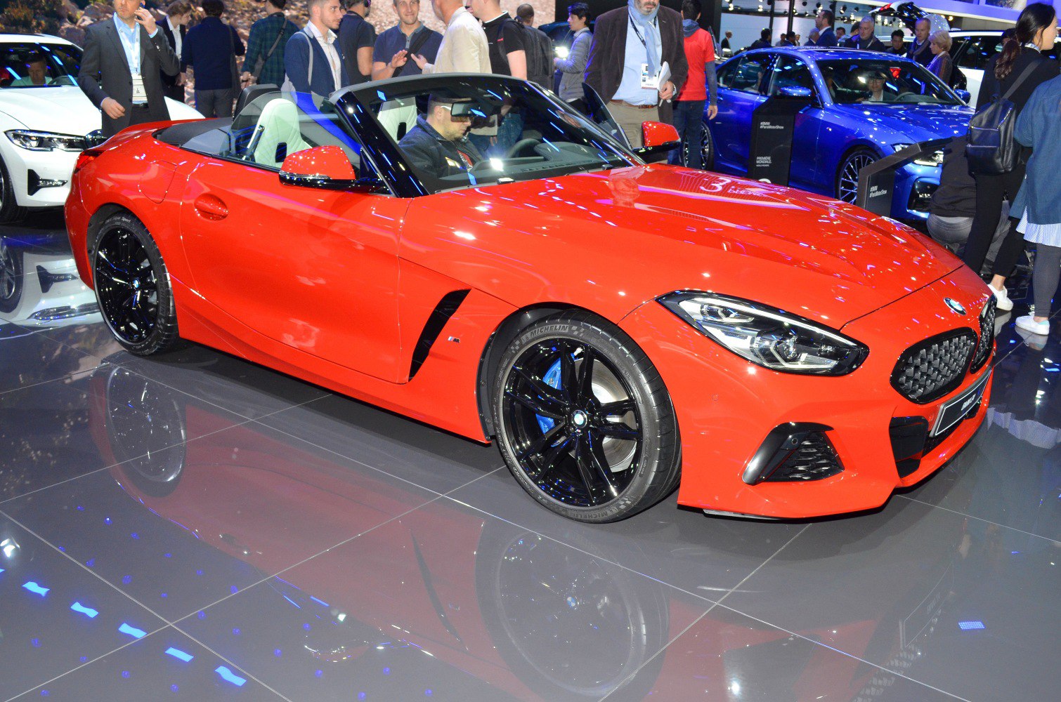 Red sporty convertible with black alloy wheels and aggressive front grille
