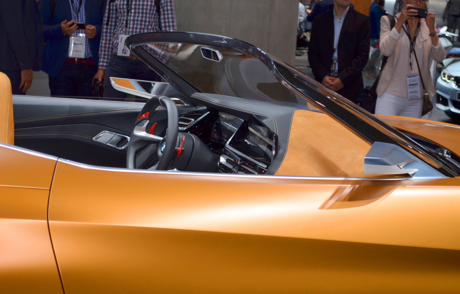 Convertible sports car interior and side profile with steering wheel and modern dashboard.
