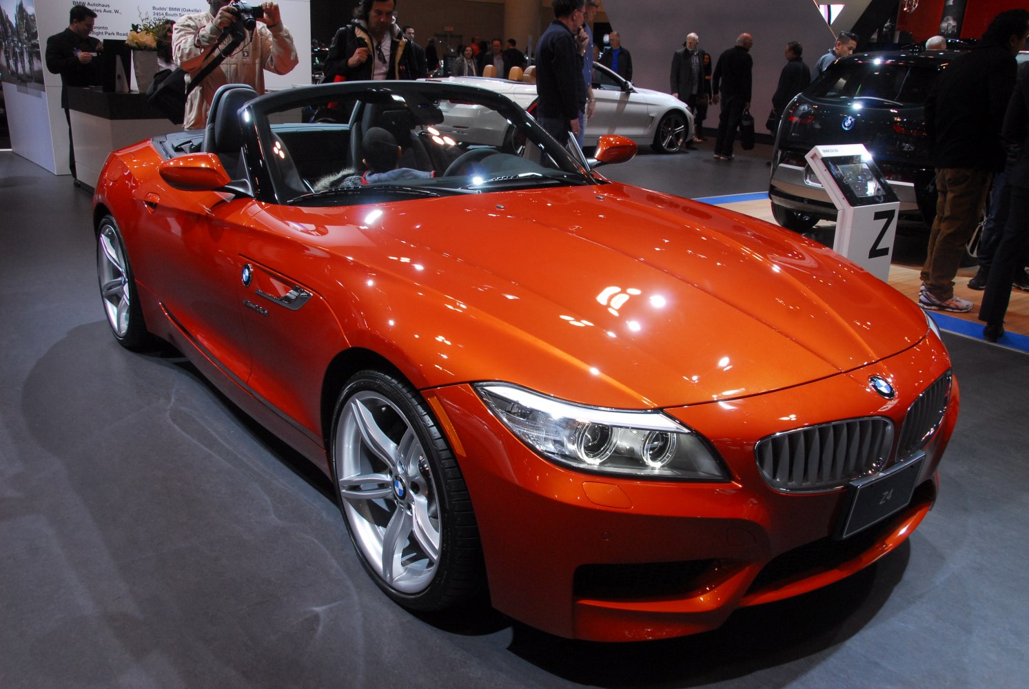 Convertible sports car front with twin round headlights and bold hood lines