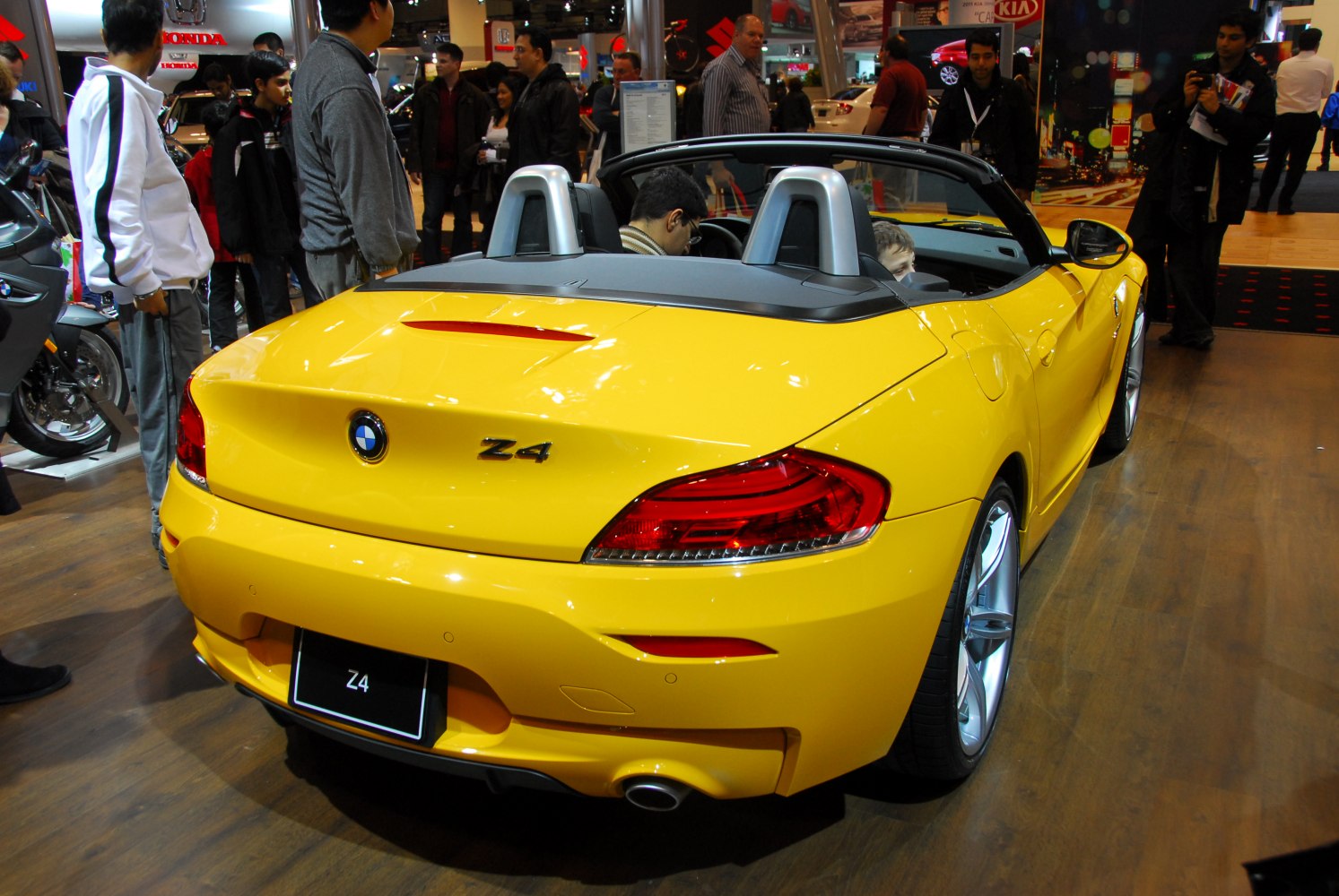 Yellow convertible rear with distinctive taillights and silver roll bars