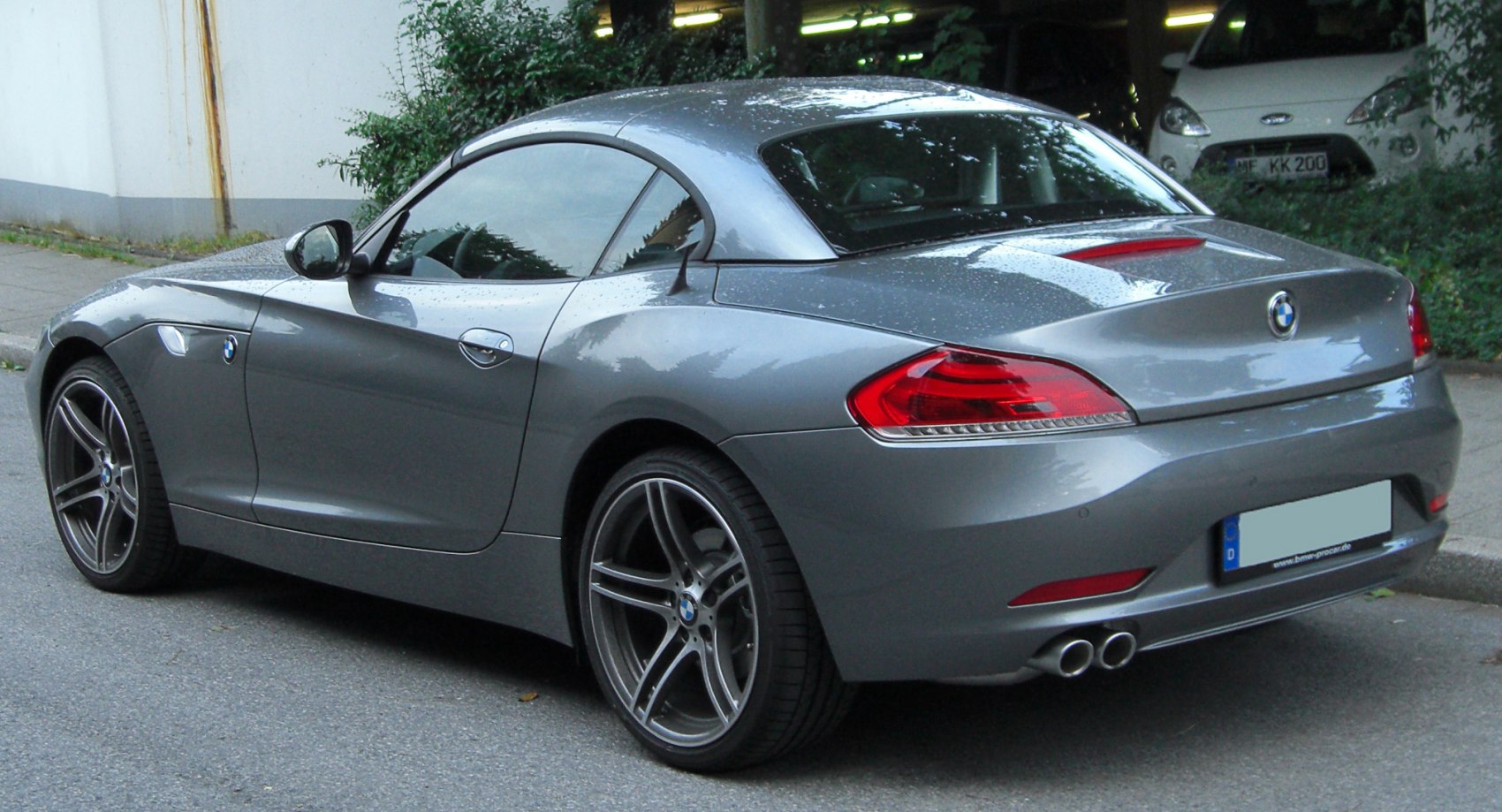 Rear side profile of hardtop coupe with dual exhaust and alloy wheels