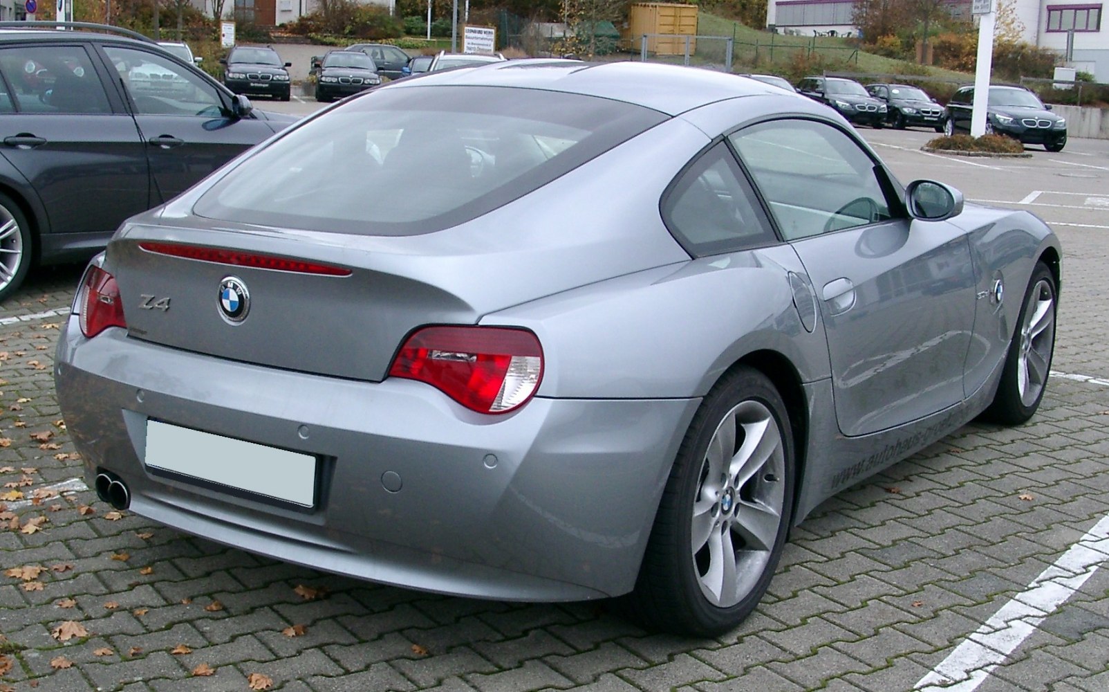 Rear and side view of a sleek sporty coupe with smooth curves and dual exhaust.