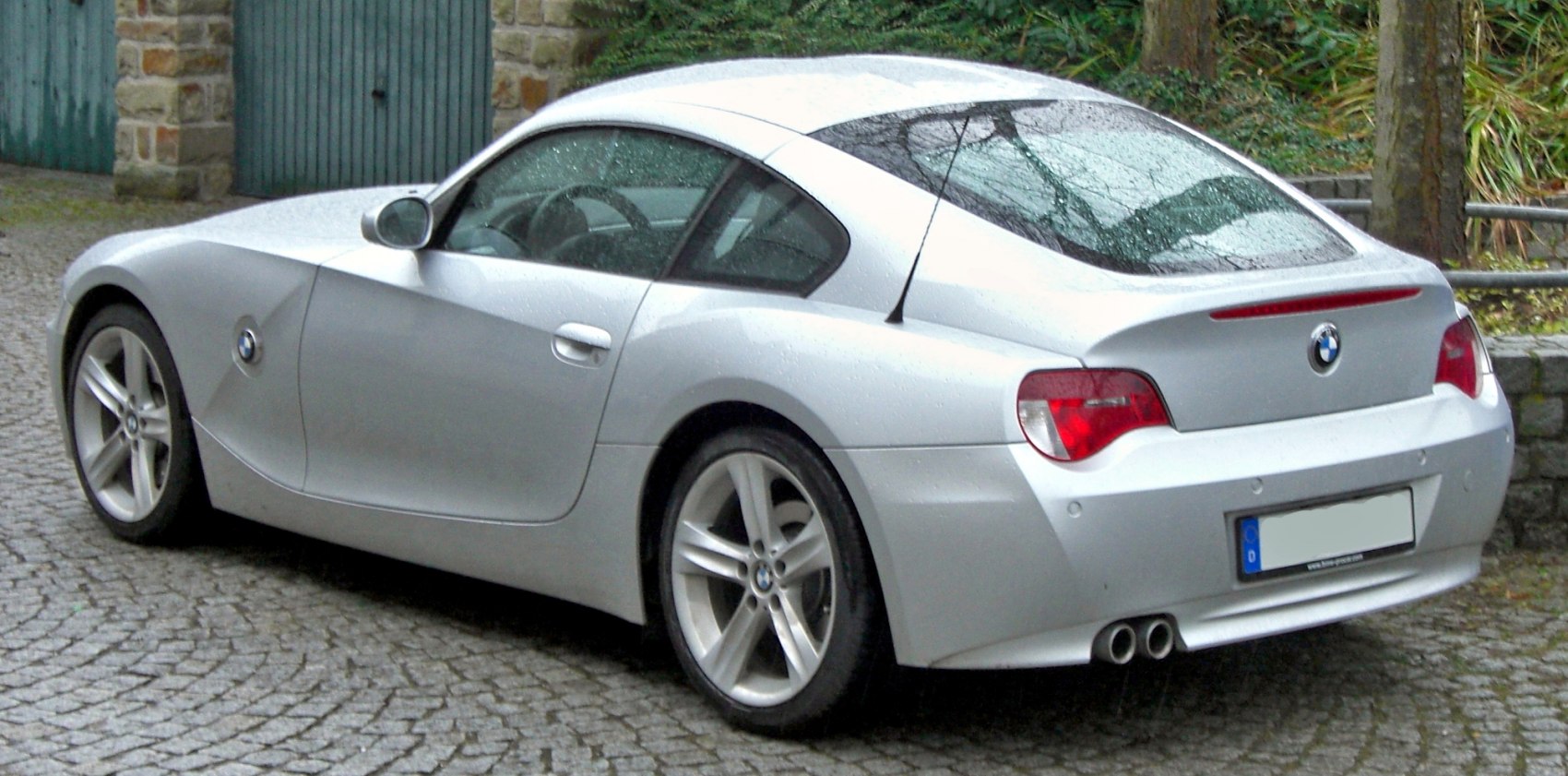 Silver coupe with rear view, dual exhaust, and alloy wheels
