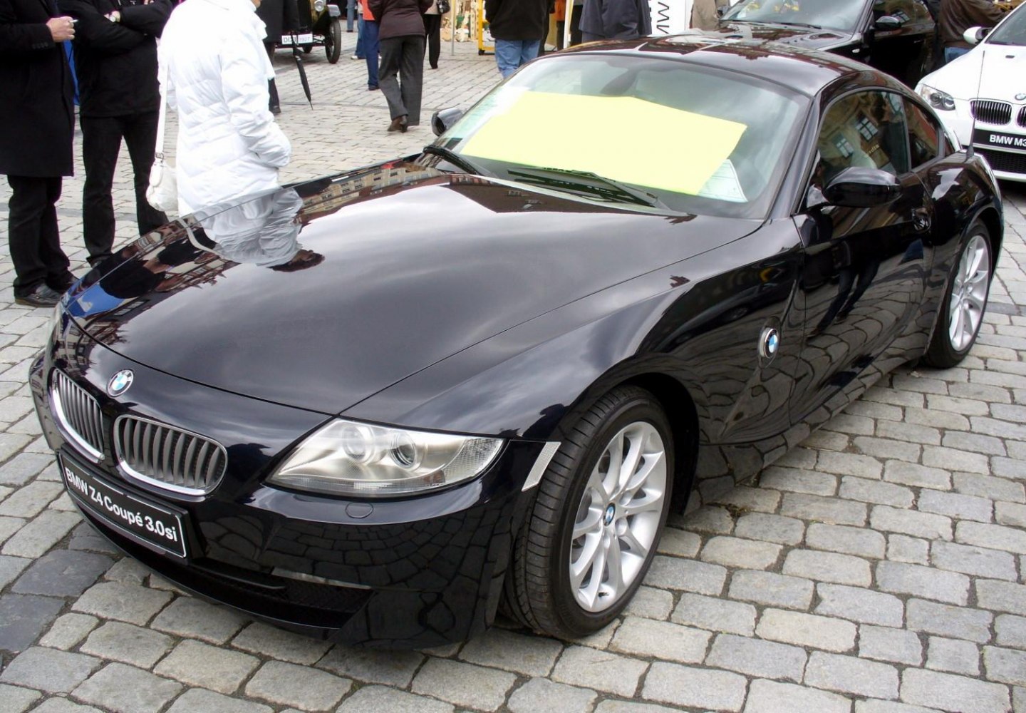 Front quarter view of a black coupe with distinctive headlights and grille