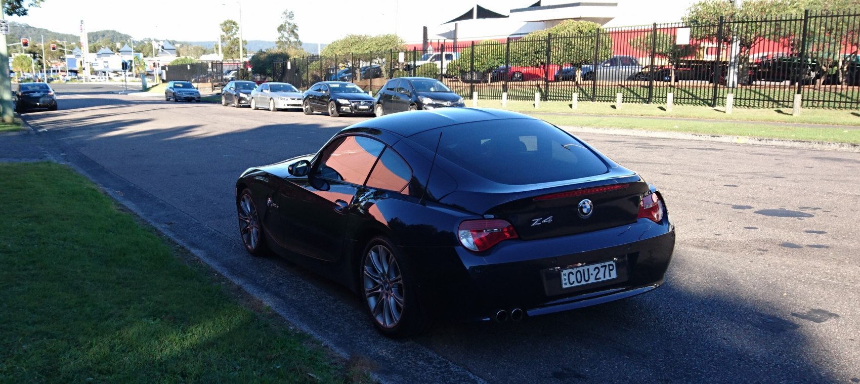 Rear view of a black sporty coupe with dual exhaust and distinctive taillights.