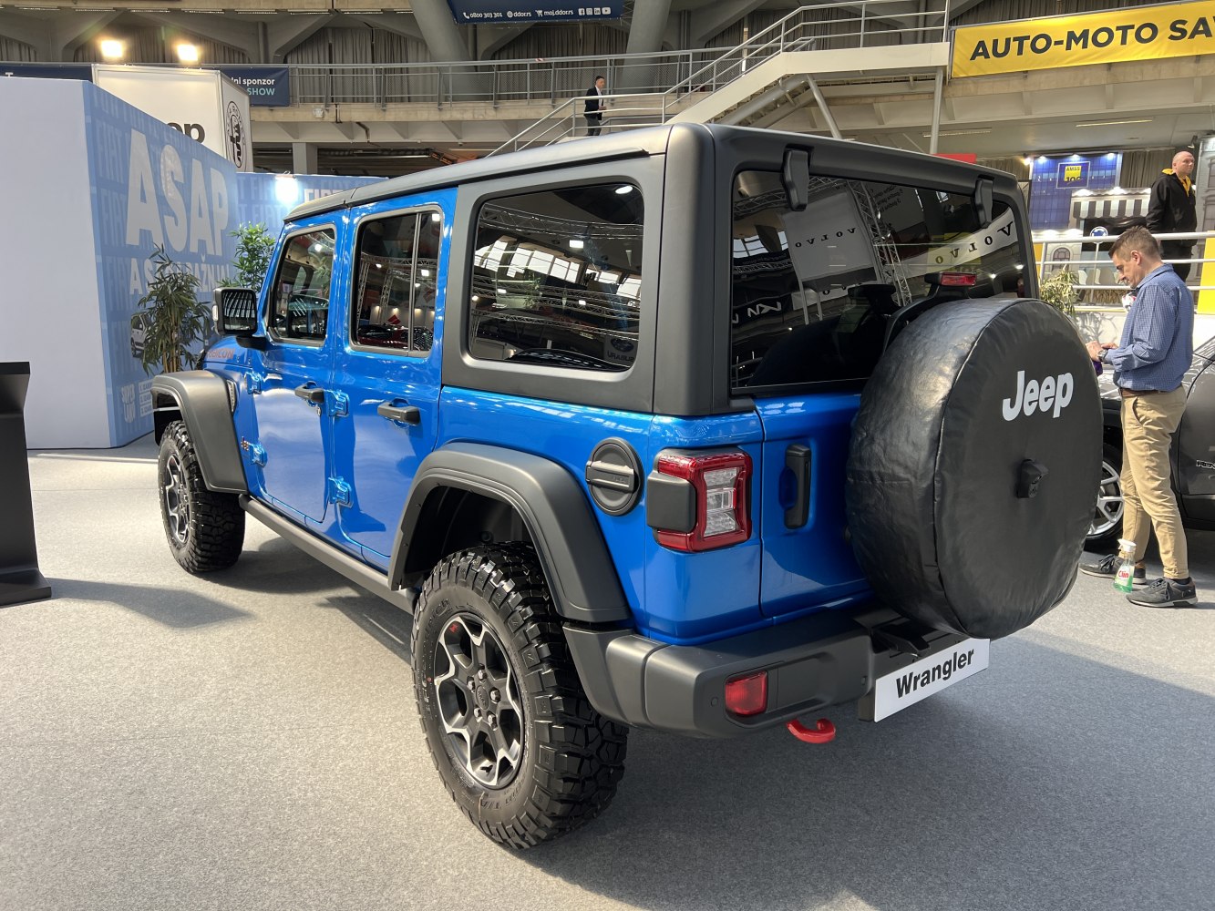 Rear and side view of blue SUV with spare tire on tailgate and off-road tires