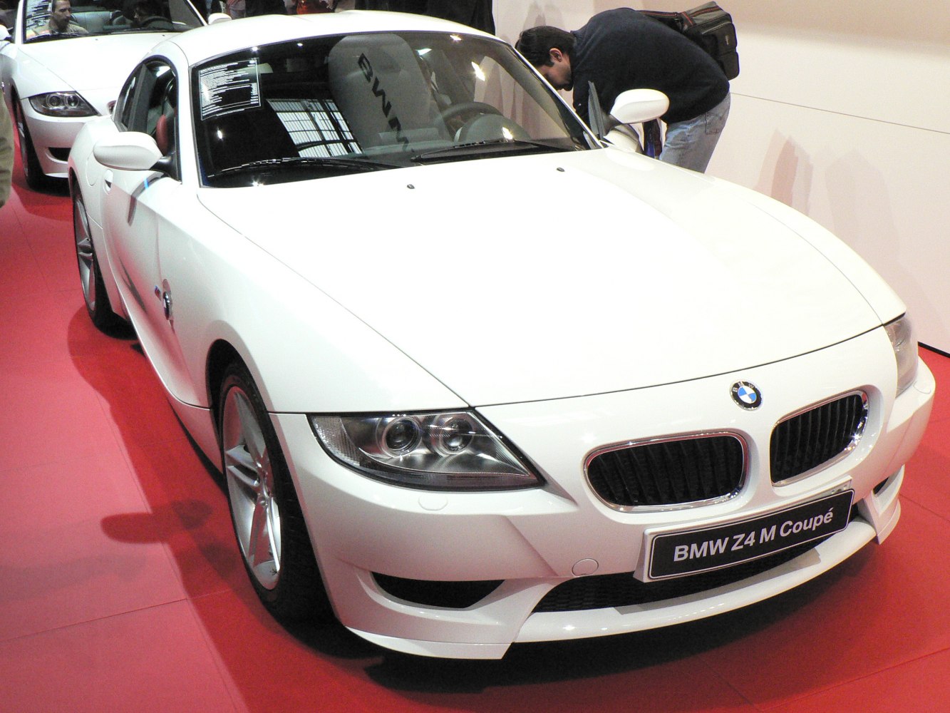 Twin headlights and kidney grille on aerodynamic white coupe front