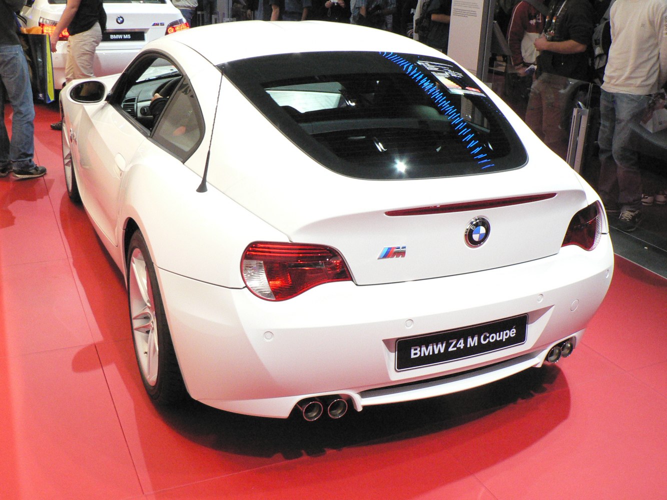 Rear view of sporty coupe with M badge and dual exhaust