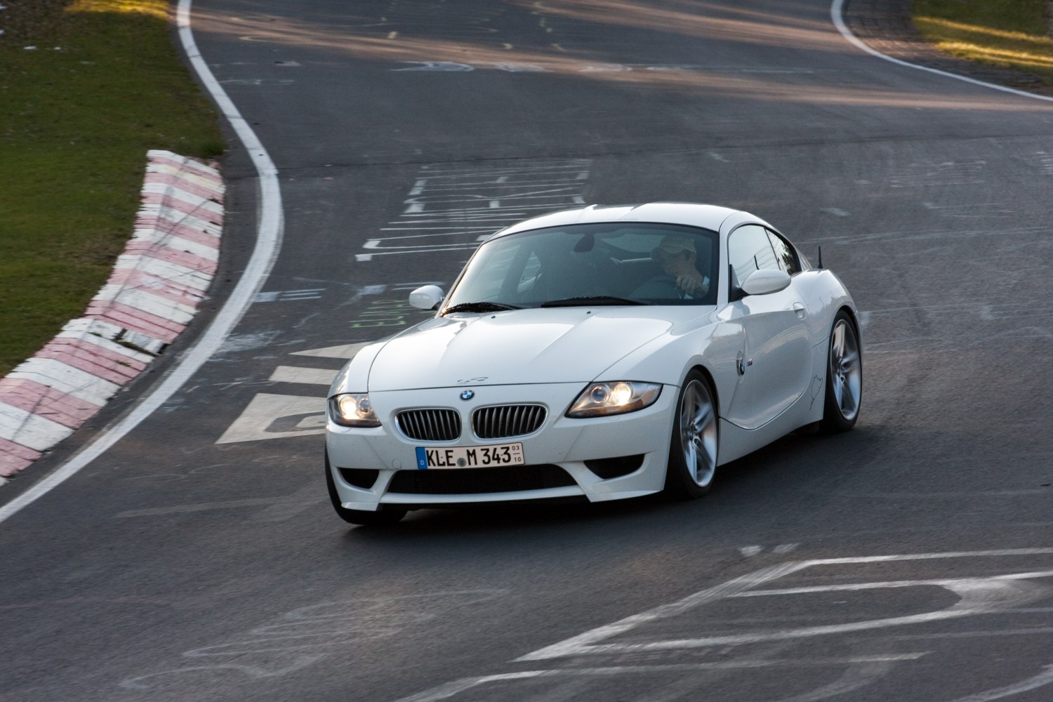 Front view of white Z4 coupe cornering on race track