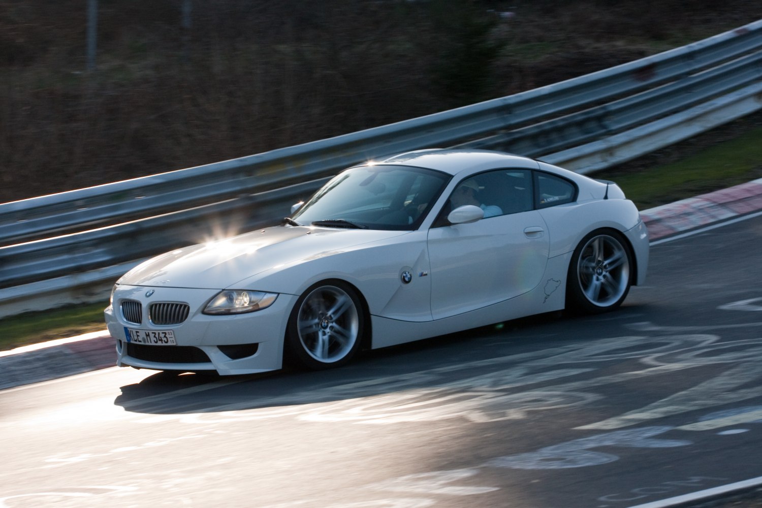 White sporty coupe on racetrack with dynamic handling