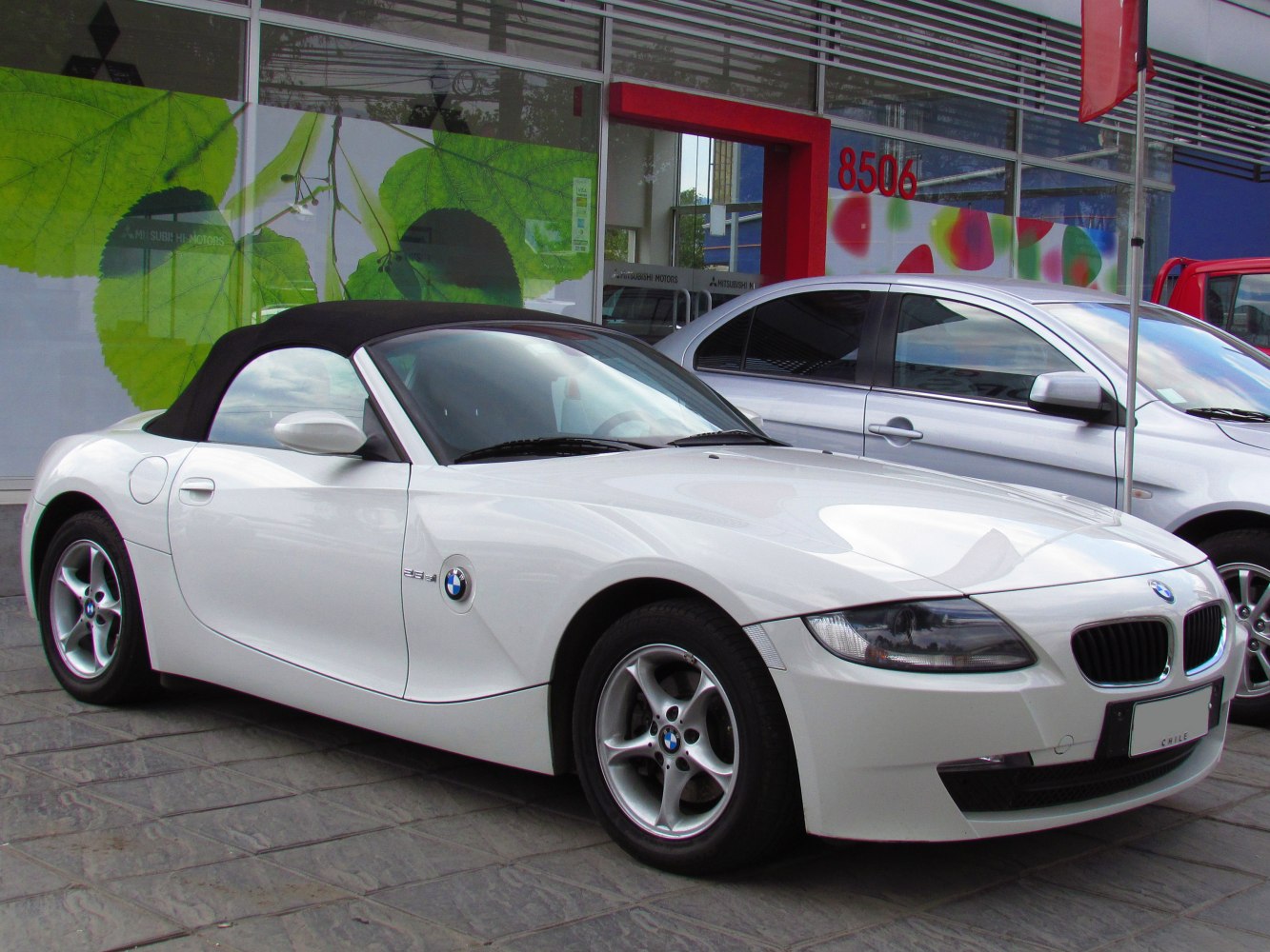 White convertible BMW Z4 E85 LCI front side view with black soft top roof