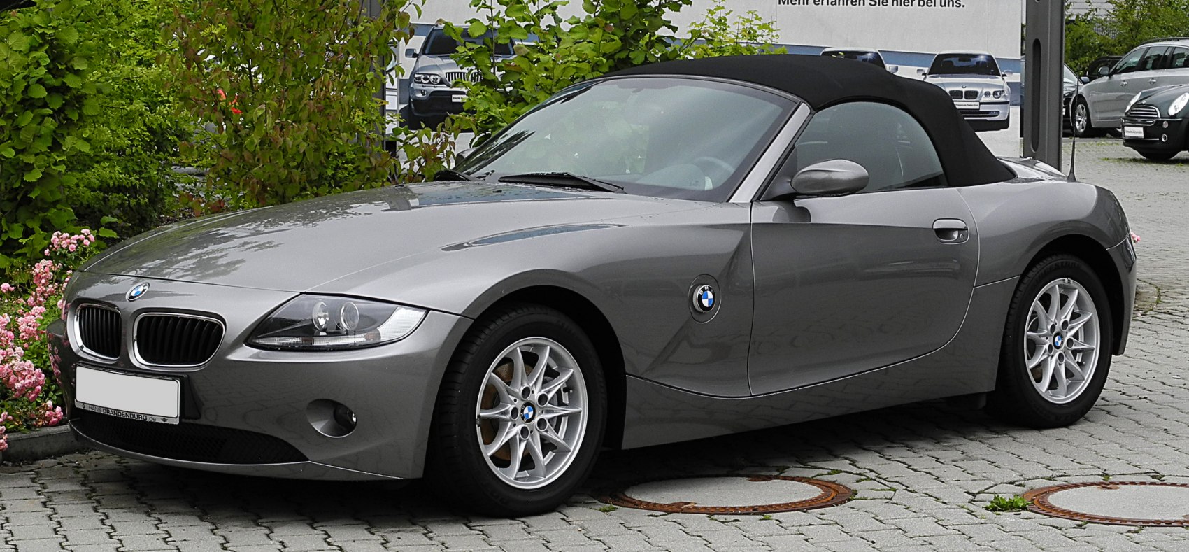 Silver convertible roadster with soft top, front and side view