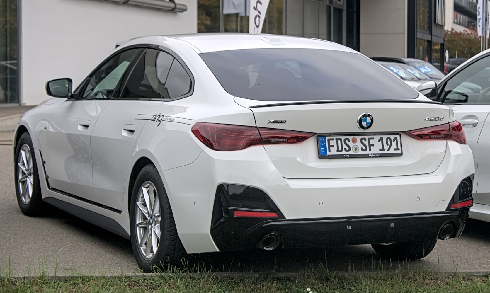 Rear view of a sleek white Gran Coupe with distinctive tail lights and xDrive badge