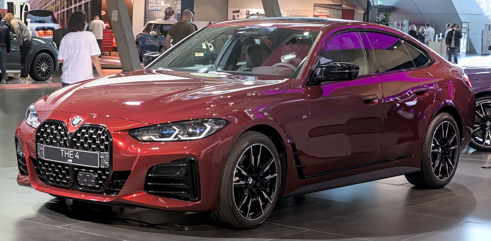 Red 4 Series Gran Coupe front fascia and side profile with black wheels